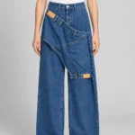 Φαρδύ τζιν Noera Concept P13672 σε μεσαίο μπλε denim, μπροστινή όψη με ενσωματωμένες διαγώνιες λεπτομέρειες